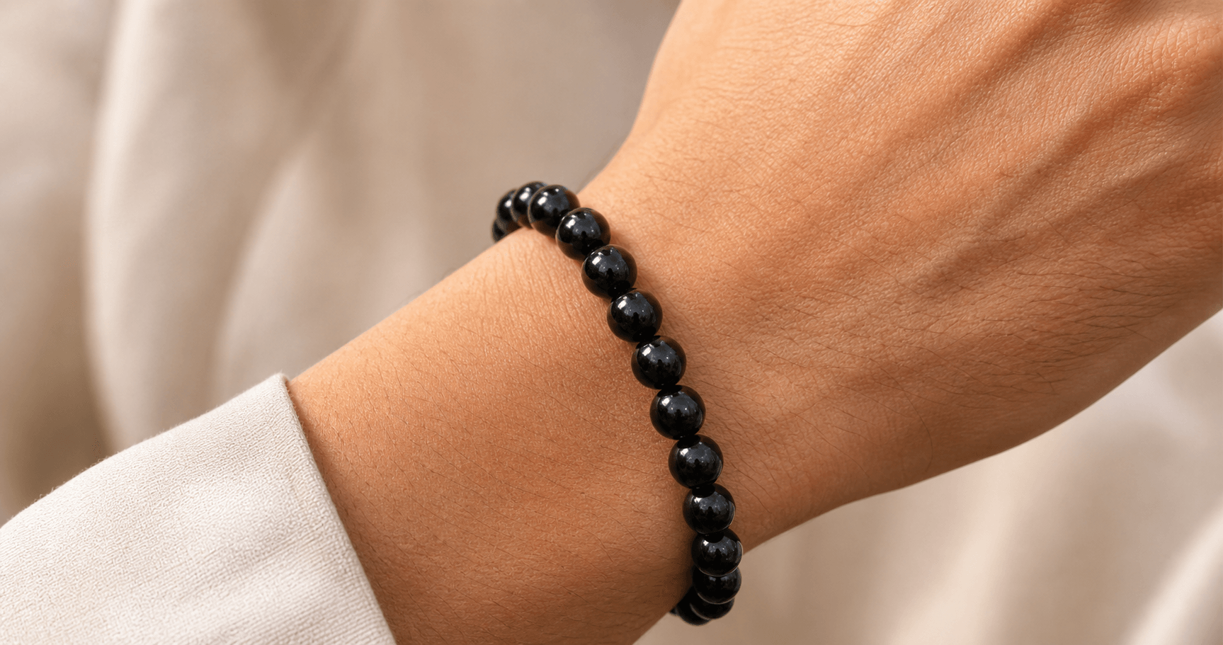 Generate an image of hero image in the context of "A black obsidian bracelet on my wrist, as shown in the actual photo.".